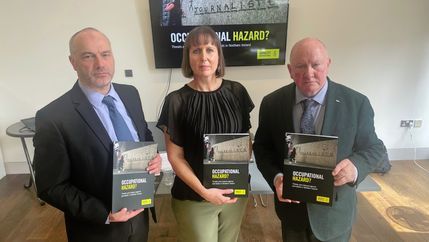 Patrick Corrigan, Kathryn Torney, and Séamus Dooley holding Amnesty's 'Occupational Hazard?' report.