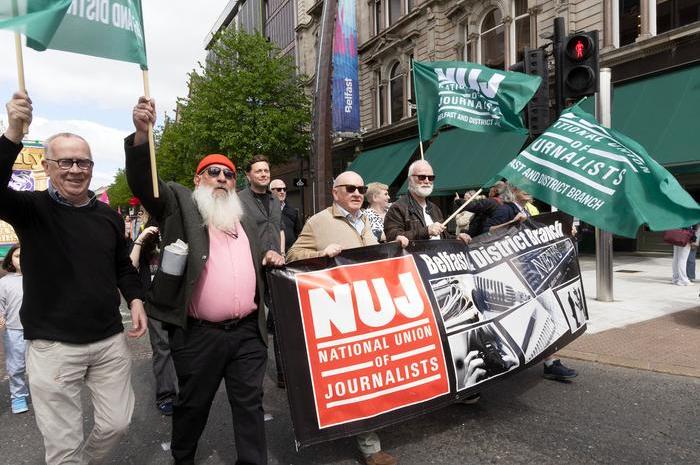 NUJ Belfast and District branch members hold banners and placards while marching at the 2025 May Day parade.