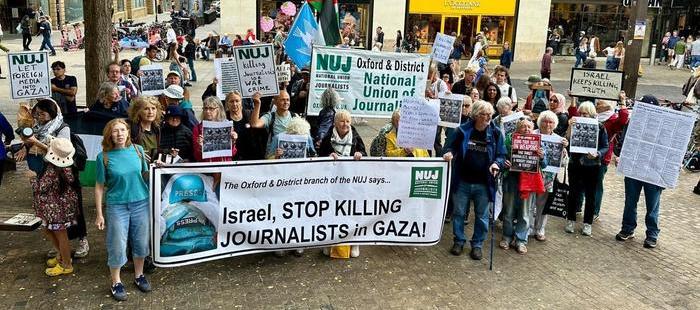 Members holding banner that reads, 'Israel, stop killing journalists in Gaza'