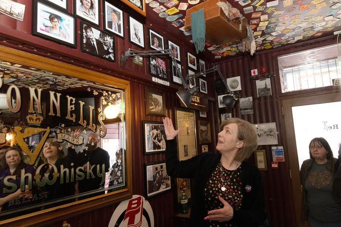 Nicola McKee Corner wearing a black cardigan and patterned dress speaks about her sister Lyra McKee at The Reporter bar in Belfast.