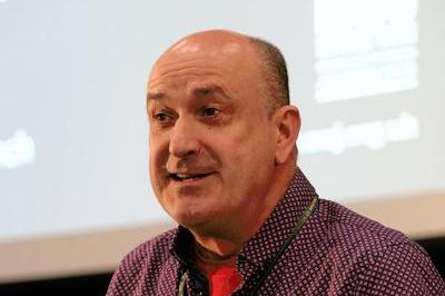 Gerry Curran wearing a patterned shirt speaks at DM 2025.